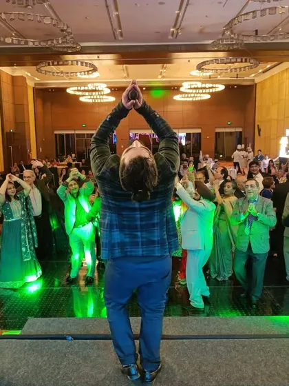 Leading the crowd in a moment of shared joy and dance during a 50th-anniversary event. Whether it's a wedding or a jubilee, my goal is to get everyone on their feet and celebrating together.