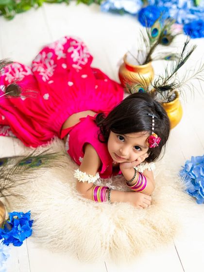 A playful pose from our little Radha, lying amongst peacock feathers and pots. I create different angles and poses to give you a full gallery of beautiful images.