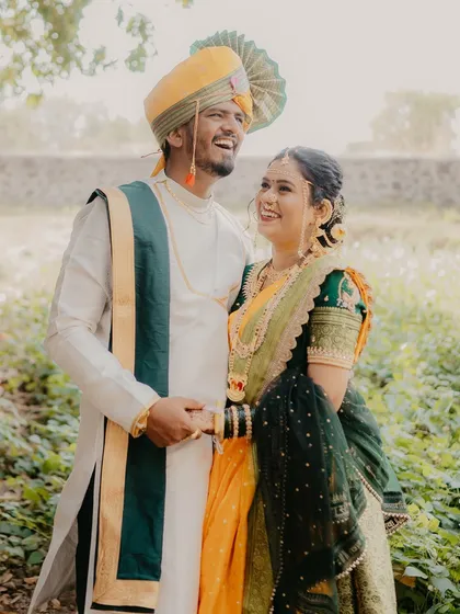 A candid shot of the couple sharing a laugh in a beautiful outdoor setting. Their genuine smiles and relaxed posture show the fun and happiness of their pre-wedding shoot.
