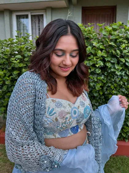 Another angle of the blue eyeshadow look, showing how it beautifully complements the embroidery on her outfit.