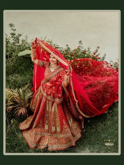 A playful and happy portrait of the bride, lifting her veil in a beautiful garden, her joy shining through.