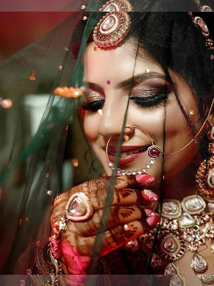 A shy, smiling bridal portrait taken through her veil, capturing a classic and delicate moment.
