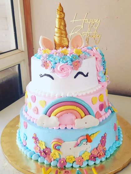 A close-up of our three-tier unicorn cake, showcasing the colorful details and the happy unicorn face.