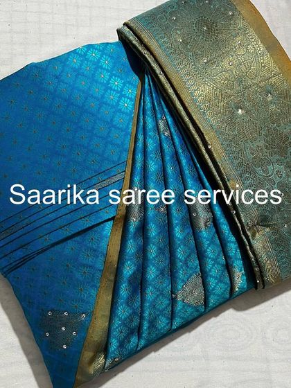 This sparkling blue saree is perfect for an evening party. It's been pleated to catch the light beautifully.