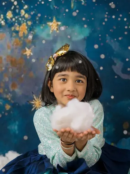 Holding a piece of the sky. This creative shot of a girl holding a cloud adds a touch of magic and wonder to her celestial-themed photoshoot.