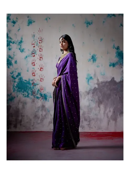 This classic purple saree with delicate buti work is a perfect example of understated elegance. It’s a timeless piece that can be dressed up or down for any festive occasion.