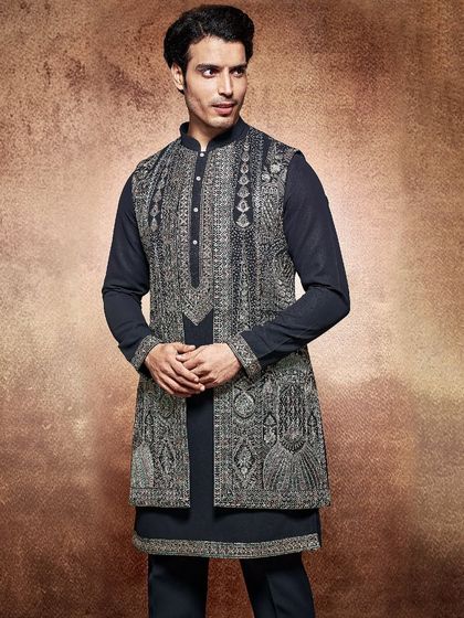 This black-on-black ensemble features a long, embroidered jacket over a matching kurta. It is a powerful and elegant look, designed for formal evening celebrations.