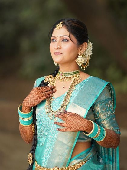 A classic portrait showcasing the full splendor of the South Indian bridal look, from the intricate jewelry to the beautifully draped saree.