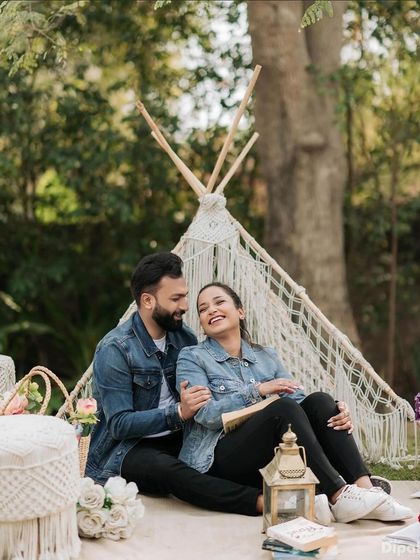A fun and casual pre-wedding picnic scene. The makeup is minimal and natural, perfect for a relaxed, daytime shoot.