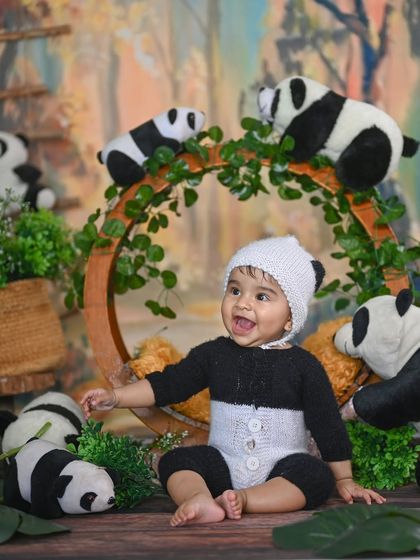 A happy little panda! The smile on this baby's face makes the whole setup even more adorable.