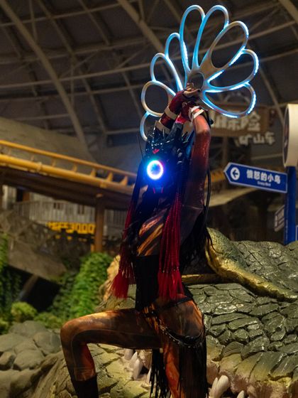 A different pose from our Alien LED show, highlighting the intricate details of the costume and the glowing props against a themed backdrop.