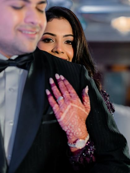 An intimate hug on the dance floor. The bride's glance towards the camera, with her henna-adorned hand on his shoulder, makes for a beautiful, candid shot.