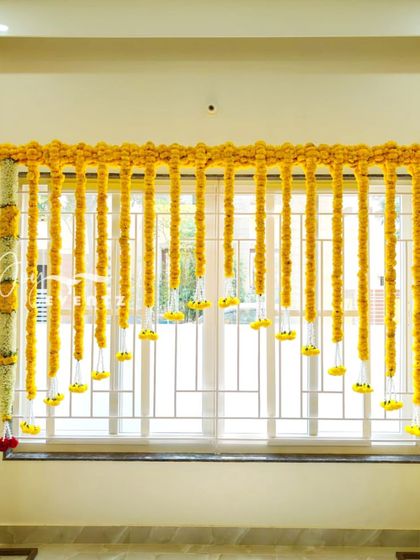 We can turn any part of your home into a beautiful photo spot, like this window frame decorated with marigold garlands. This simple setup is perfect for traditional photos during a half saree function.
