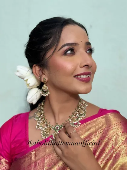 A close-up of the festive Diwali makeup, showing the shimmery eye makeup and a deep pink lip, paired with a traditional necklace.