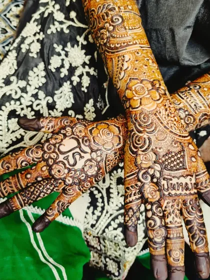 A stunning bridal mehndi with the groom's name 'Junaid' and the couple's initials 'JS' incorporated into the design.