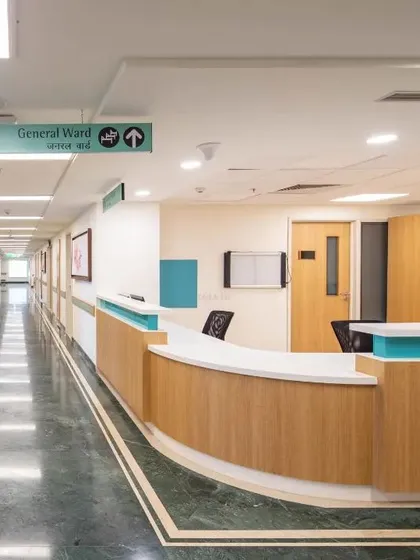 This nurses' station and corridor at Max Super Speciality Hospital are designed for efficiency. The curved desk allows for easy interaction, and clear signage directs staff and patients through the general ward.