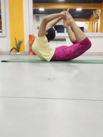 Another student holding Dhanurasana (Bow Pose), showing the strength and flexibility developed through dedicated practice.