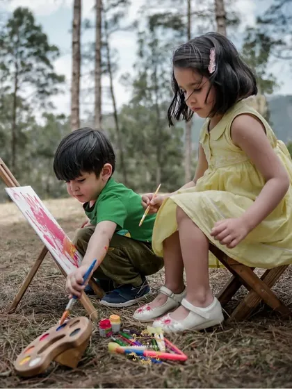 Two young siblings lost in their own creative world, painting together during an outdoor session. I love creating setups that let kids be themselves, resulting in natural and artistic photographs.
