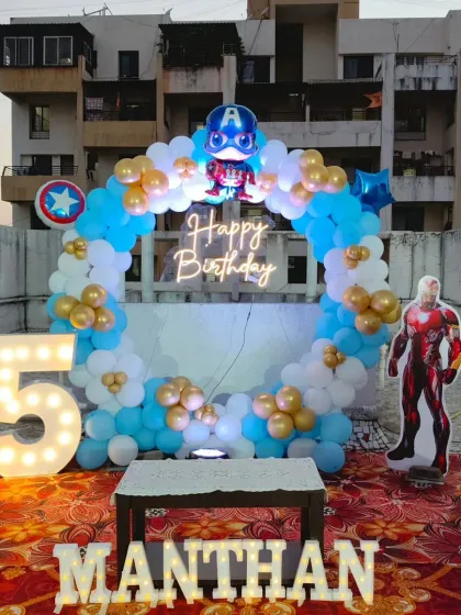 I bring superhero adventures to life with themes like this Avengers party, perfect for an outdoor terrace celebration. The setup includes a circular balloon arch in Captain America's blue, white, and gold colors, a "Happy Birthday" neon sign, and life-sized cutouts of characters like Iron Man. I also offer personalized marquee letters for the birthday boy's or girl's name.