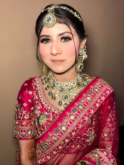 A close-up of the bride's jewelry, showing the intricate details of the polki set and matching mathapatti.