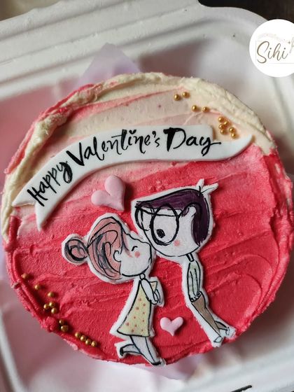 A cute, cartoonish couple illustration makes this Valentine's Day bento cake extra special. The hand-drawn characters and pink ombre frosting create a playful and romantic vibe.