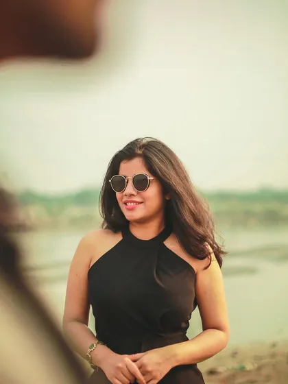 A beautiful, sun-kissed portrait of the bride-to-be, captured from the groom's perspective during their outdoor pre-wedding session.
