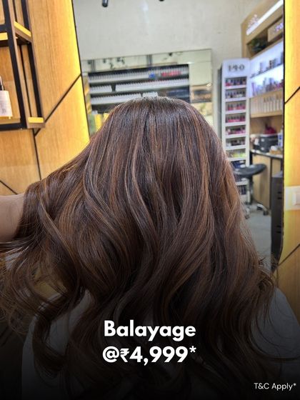 An example of our Balayage service, offered at our Kandivali location. The image shows a beautiful blend of colours on wavy hair.