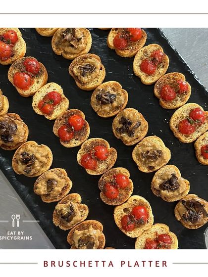 A classic Bruschetta Platter with a variety of toppings, from traditional cherry tomato and basil to savoury mushroom, presented on a sleek black slate.