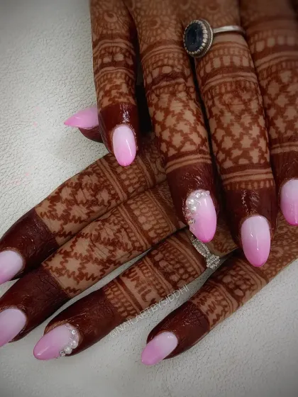 A perfect example of my custom bridal nail service. This set features a soft pink and white ombre design, with a delicate placement of rhinestones on the accent nail, designed to beautifully complement traditional henna.