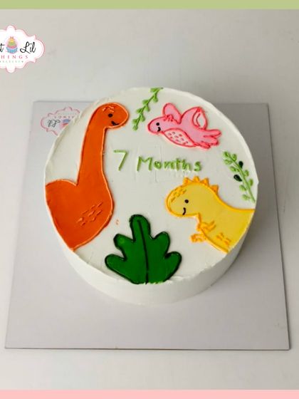 A rawr-some monthly milestone cake. This cute minimalist cake celebrates 7 months with simple, colorful dinosaur drawings.