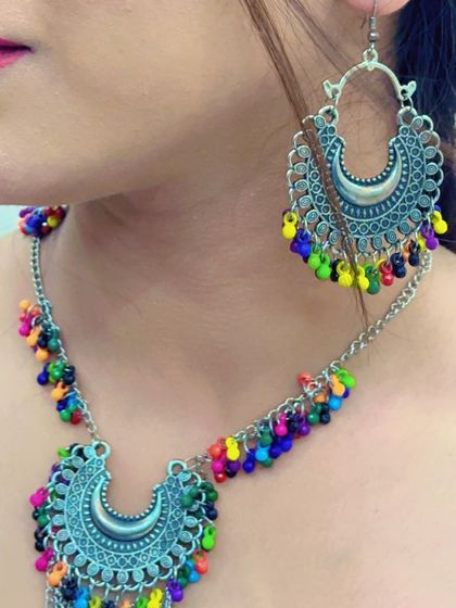 A silver necklace and earring set with multi-colored beads, designed in a traditional half-moon shape.