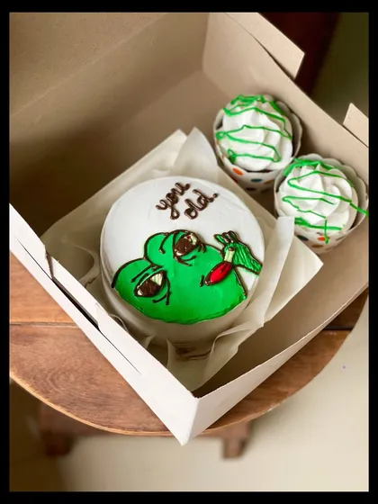 Bring some humor to a birthday with this "You old" meme cake combo. The bento features a funny green character, paired with two cupcakes with matching green drizzle.