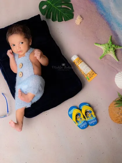 Awake and taking it all in. This little one is enjoying his first trip to the beach, complete with tiny flip-flops and a pineapple prop.