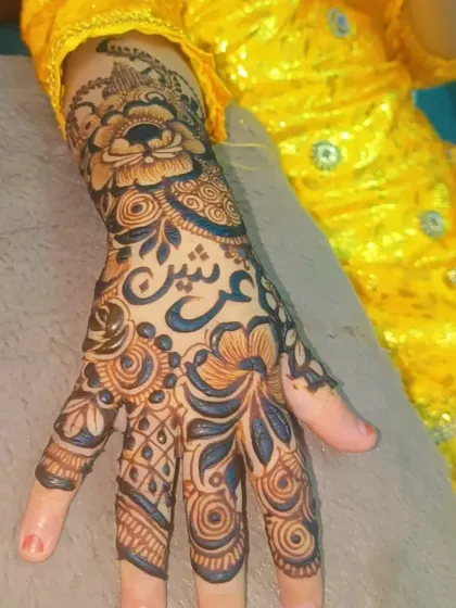 A floral henna design for a little one, with her name 'Arsheen' beautifully written in the pattern.
