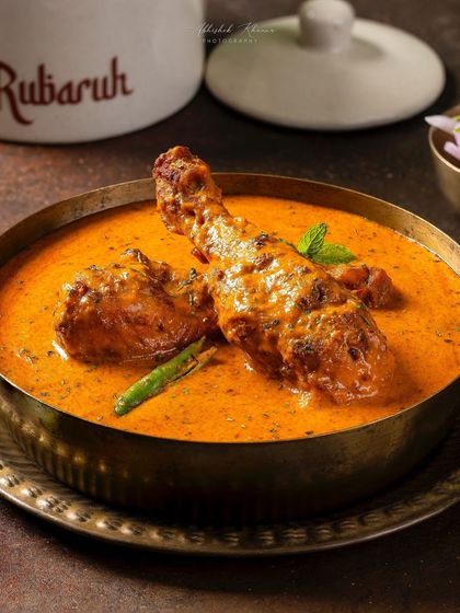 A close-up of Chicken-e-Rubaruh, a signature creamy chicken curry. This shot for Rubaruh highlights the rich gravy and tender chicken, styled in traditional brassware to reflect the brand's identity.