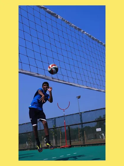 A young player learning to spike, with me in the background. It is rewarding to see them fly.