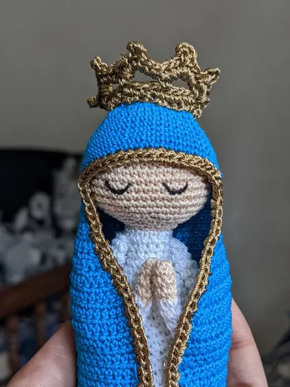 The Mother Mary doll held in hand, giving a sense of its size and craftsmanship.