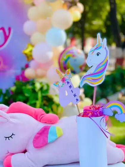 A cute plush unicorn and themed toppers make for a lovely decorative element on the gift or cake table.