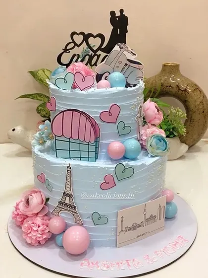 This thoughtful two-tier engagement cake tells the couple's story, depicting their journey of togetherness across Paris and Berlin. It's decorated with edible prints of the Eiffel Tower, hearts, and a scooter for a truly personal touch.
