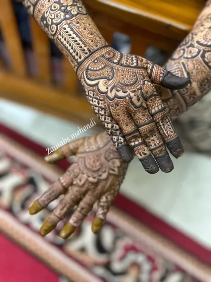 A beautiful shot of Hibah's Pakistani bridal henna, with both hands adorned in a symmetrical and intricate design.