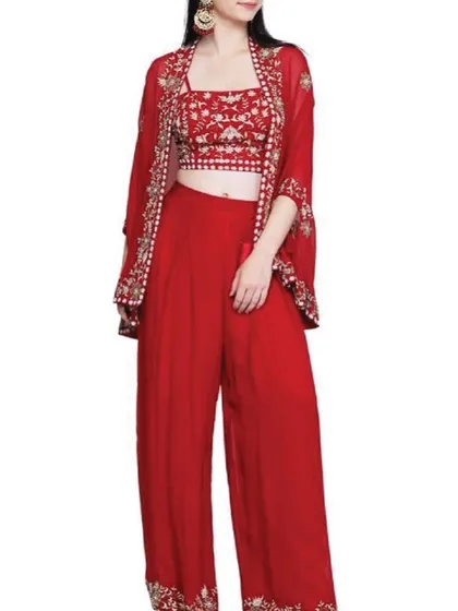 This vibrant red three-piece set, featuring a crop top, palazzo pants, and a matching embroidered jacket, is a modern take on festive wear. It's a versatile outfit that offers both style and comfort for any celebration, from a mehendi ceremony to a festive party.