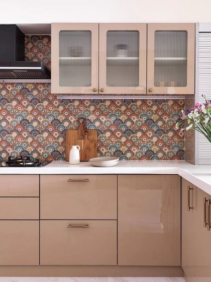 This kitchen is a blend of functionality and low-maintenance elegance. The colorful backsplash tiles harmonize with the acrylic beige cabinets to create a visually appealing and cohesive atmosphere.