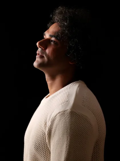 A dramatic profile shot of Alok Singh. Using strong side lighting against a black background creates a sculpted, powerful look.