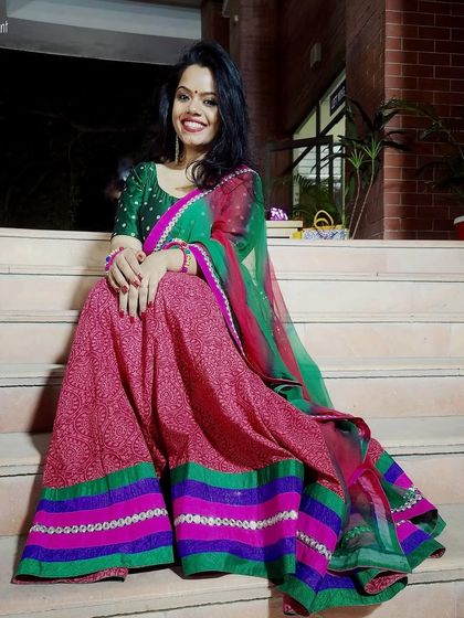 A vibrant pink and green lehenga that radiates joy. The colorful borders and cheerful design make it a wonderful choice for festive gatherings.