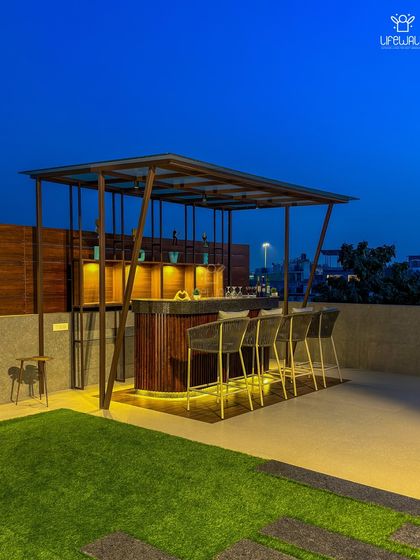 A different angle of the "LOVE" bar, showing how it integrates with the surrounding green lawn and seating area. The lighting makes it a standout feature at night.
