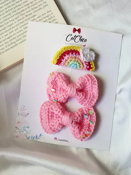 A sweet set of pink-themed clips, featuring two candy-sprinkled bows and a small rainbow clip.
