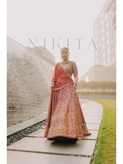 A full-length portrait of Nikita against a modern architectural backdrop. The soft, diffused light gives the image a dreamy quality, perfectly complementing her graceful presence.