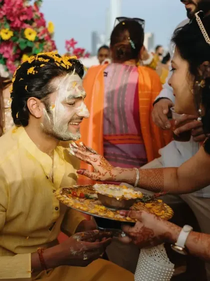 A guest applies turmeric paste to the groom during the Haldi ritual. I focus on creating an inclusive atmosphere where all guests feel involved in the traditions.