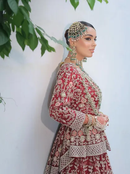 A side profile of the Nikkah bride, showing off her intricate passa and earring. The makeup is perfectly balanced, with a sharp liner and soft, glowing skin.