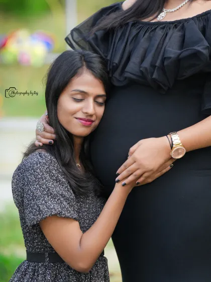 A touching moment between a mother-to-be and her friend or sister, who is listening to the baby bump.